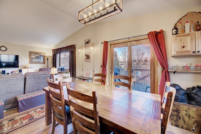 dining area featuring lofted ceiling, a healthy amount of sunlight, and light hardwood / wood-style floors