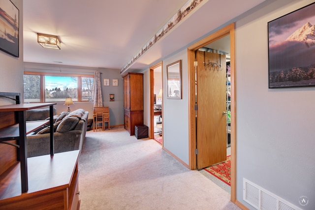 hallway featuring light colored carpet