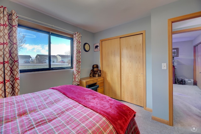 bedroom featuring light colored carpet and a closet