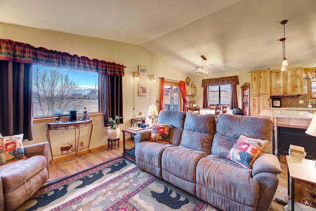 living room featuring vaulted ceiling and light wood-type flooring