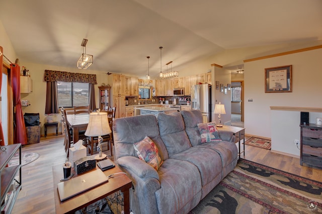 living room with light hardwood / wood-style floors and vaulted ceiling