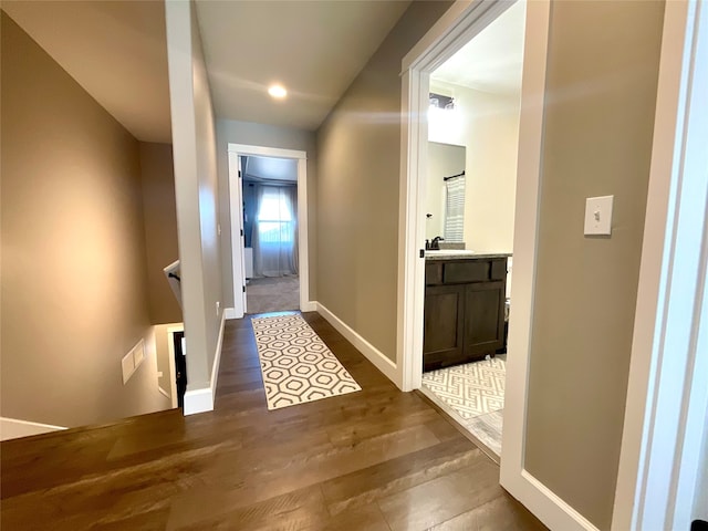 hallway with dark wood-type flooring and sink