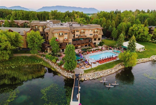 aerial view at dusk featuring a water and mountain view