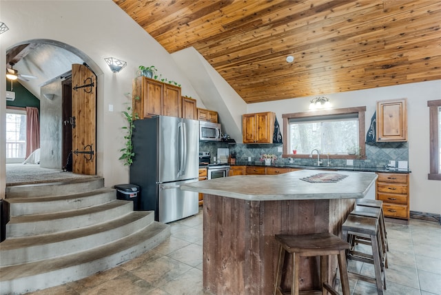 kitchen featuring sink, vaulted ceiling, ceiling fan, appliances with stainless steel finishes, and wood ceiling