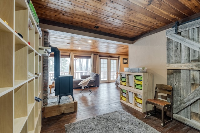 sitting room featuring a barn door, dark hardwood / wood-style flooring, wood ceiling, and french doors