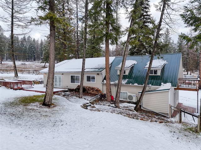 snow covered back of property featuring a deck