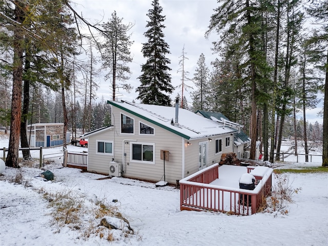 snow covered rear of property with a deck