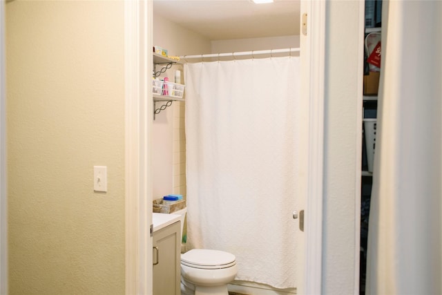 full bathroom featuring vanity, a shower with shower curtain, toilet, and a textured wall