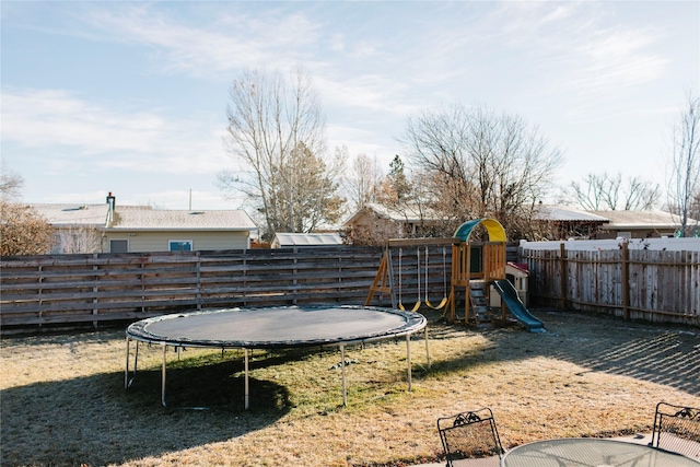 view of yard with a playground, a trampoline, and fence