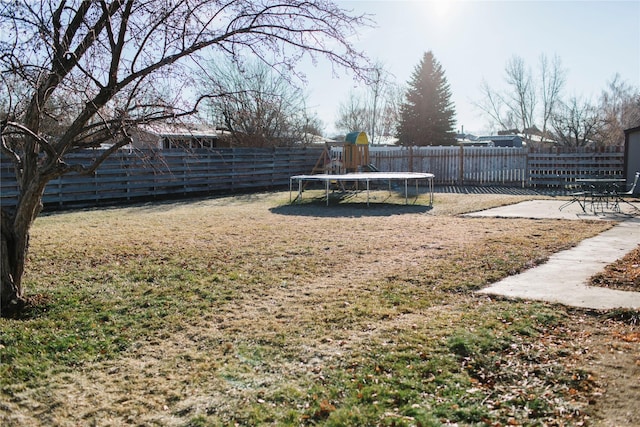 view of yard featuring a patio, a trampoline, and a fenced backyard