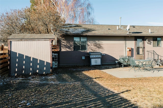 rear view of property featuring a patio, fence, and an outdoor structure