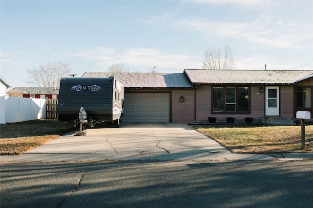 single story home featuring driveway, entry steps, fence, a front yard, and an attached garage