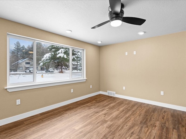 unfurnished room featuring hardwood / wood-style flooring, ceiling fan, and a textured ceiling