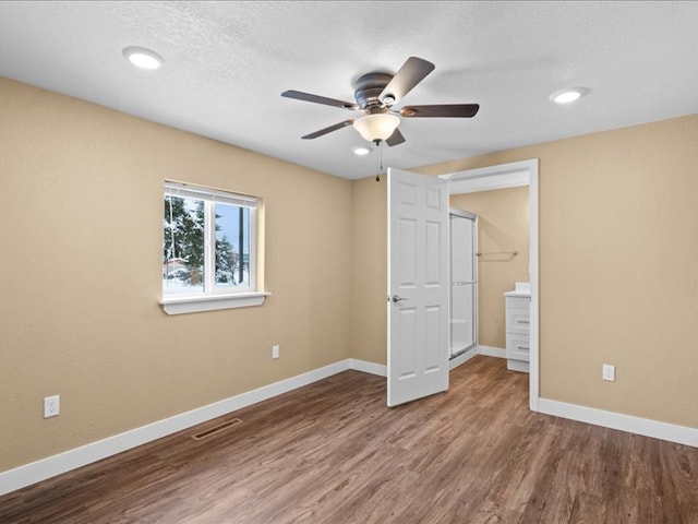 unfurnished bedroom with hardwood / wood-style flooring, ceiling fan, a textured ceiling, and connected bathroom