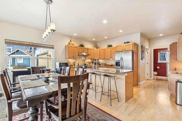 dining area with light wood-type flooring and sink