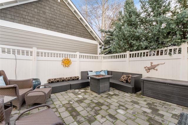 view of patio with an outdoor living space with a fire pit