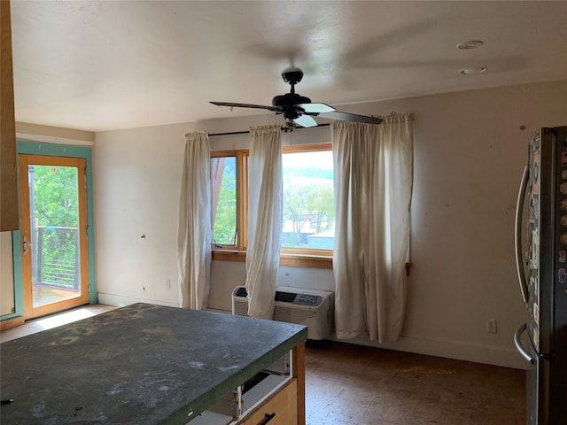 kitchen featuring ceiling fan, stainless steel fridge, and an AC wall unit