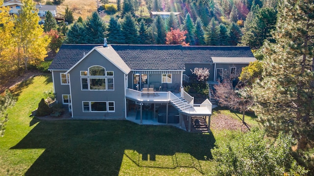 back of property featuring a yard and a wooden deck