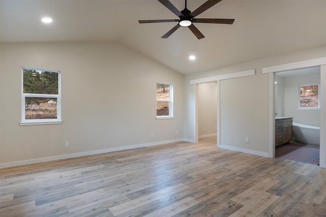 unfurnished bedroom featuring light hardwood / wood-style flooring, ceiling fan, connected bathroom, vaulted ceiling, and a closet