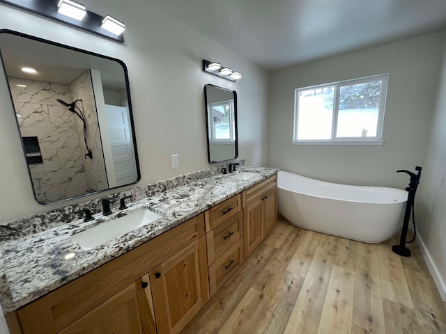 bathroom featuring vanity, hardwood / wood-style floors, and plus walk in shower