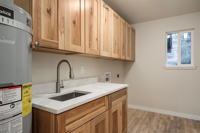 laundry area with sink, cabinets, hookup for an electric dryer, strapped water heater, and light hardwood / wood-style floors