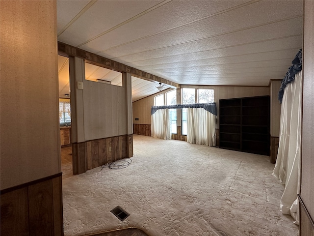 additional living space with wooden walls and lofted ceiling