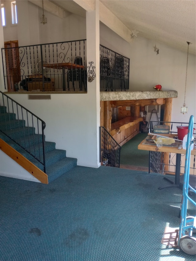 interior space with carpet flooring, high vaulted ceiling, and a textured ceiling