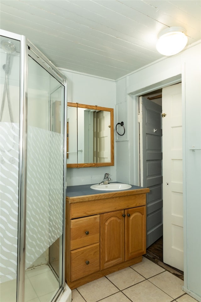 bathroom with tile patterned flooring, vanity, and a shower with door