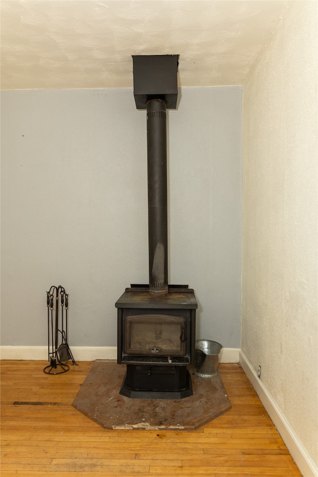 details with a wood stove and wood-type flooring