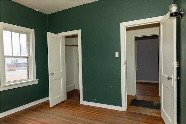 unfurnished bedroom with hardwood / wood-style flooring and a closet