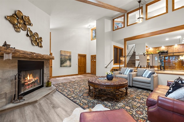 living room featuring beamed ceiling, light hardwood / wood-style floors, and high vaulted ceiling