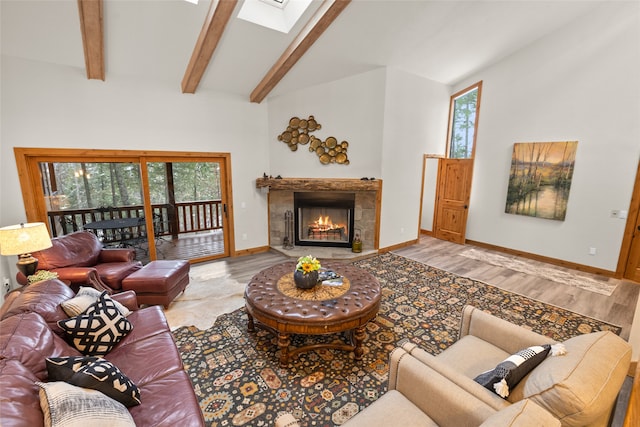 living room with light hardwood / wood-style flooring and vaulted ceiling with skylight