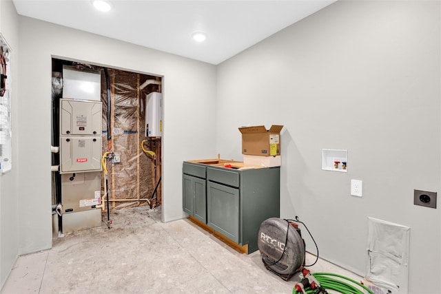 washroom with electric dryer hookup, cabinet space, washer hookup, and water heater