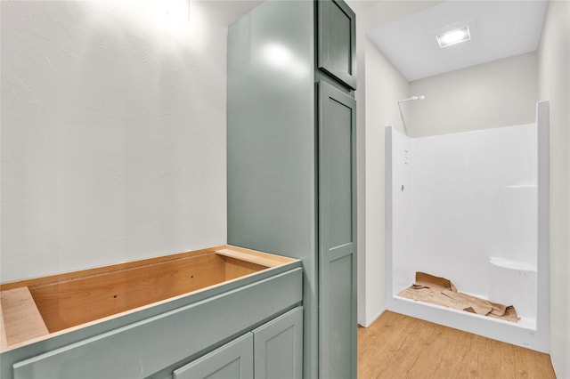 bathroom with walk in shower and wood finished floors