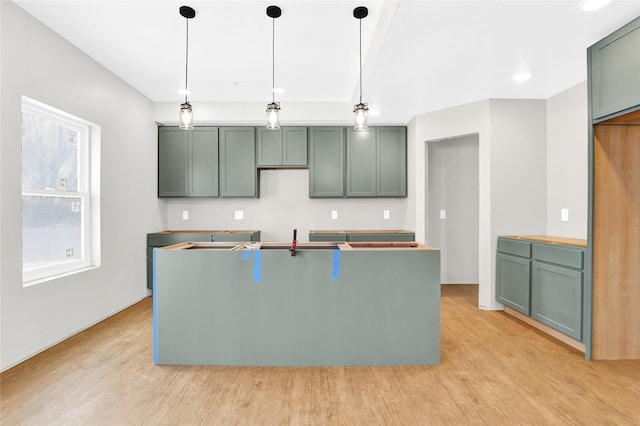 kitchen with hanging light fixtures, sink, and light hardwood / wood-style floors