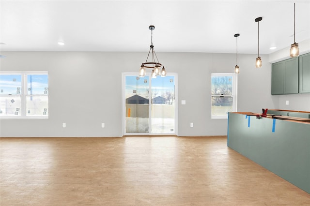 kitchen featuring light wood-style flooring, recessed lighting, hanging light fixtures, green cabinets, and a notable chandelier