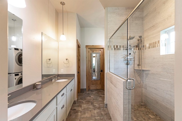 bathroom featuring stacked washer / dryer, vanity, and walk in shower