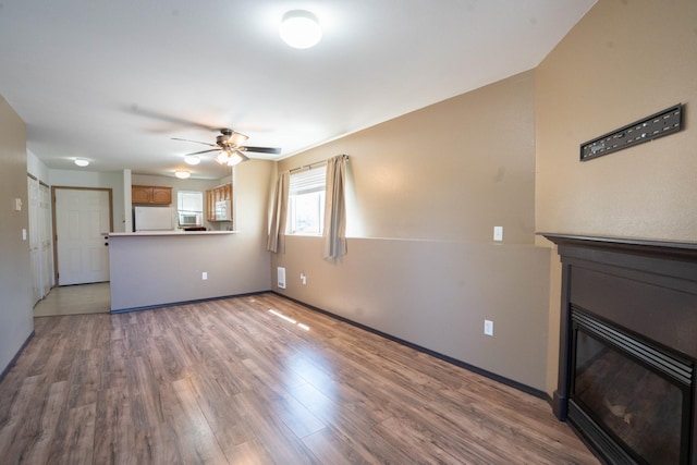 unfurnished living room with light hardwood / wood-style floors and ceiling fan