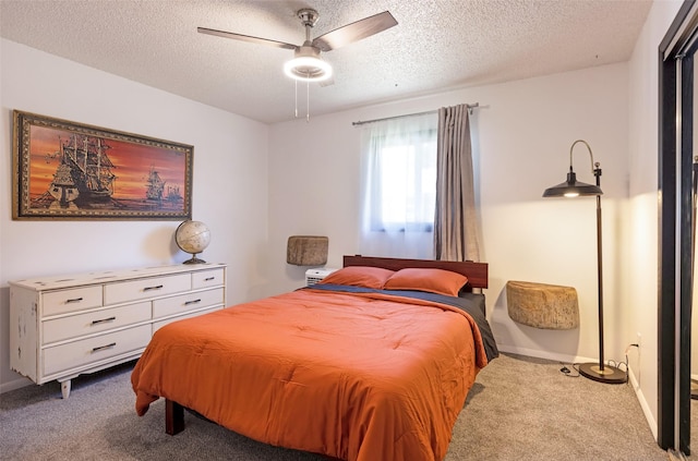 bedroom with a textured ceiling, carpet floors, and ceiling fan