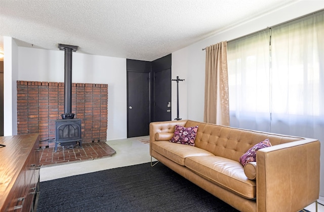 living room featuring a wood stove and a textured ceiling