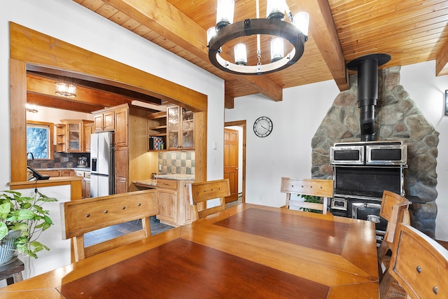 dining room with beamed ceiling, wooden ceiling, and hardwood / wood-style flooring