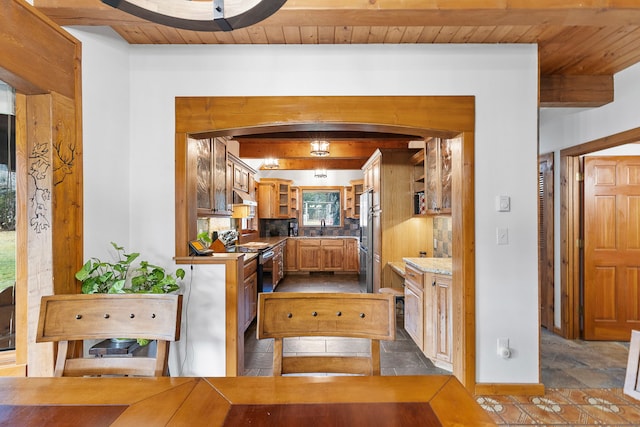 kitchen with beamed ceiling, wood ceiling, and appliances with stainless steel finishes