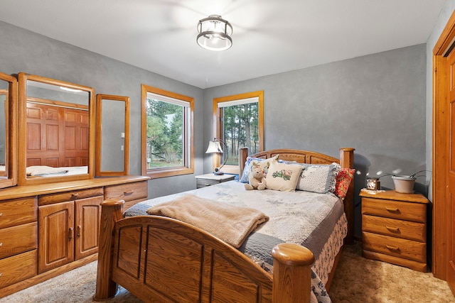 bedroom with light carpet and a closet