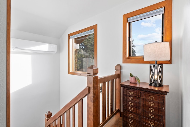 hallway with a wall mounted AC and vaulted ceiling