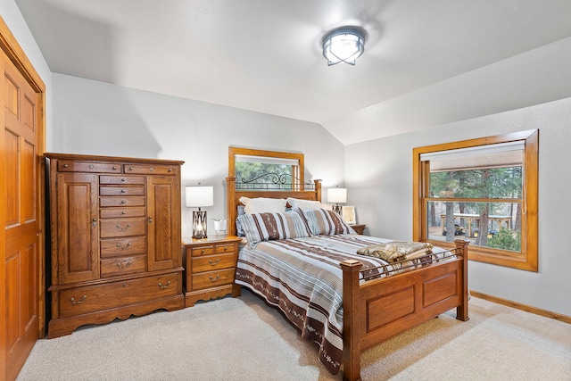 carpeted bedroom with lofted ceiling and multiple windows