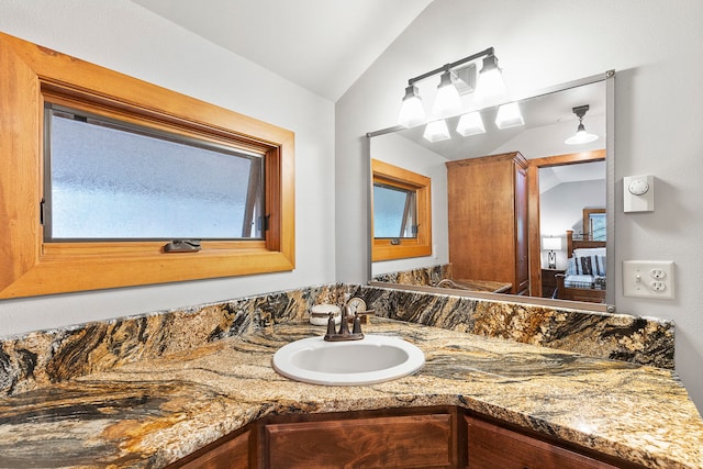 bathroom with vanity and lofted ceiling