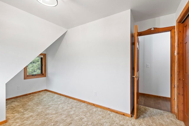 additional living space with light colored carpet and lofted ceiling