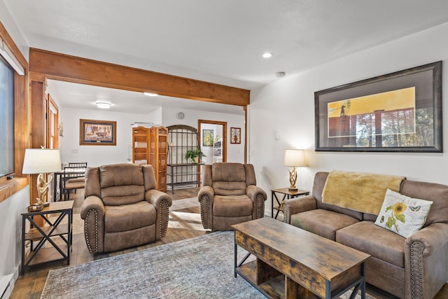 living room with beamed ceiling, plenty of natural light, and dark hardwood / wood-style flooring