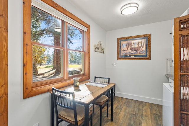 dining area featuring dark hardwood / wood-style flooring and stacked washing maching and dryer