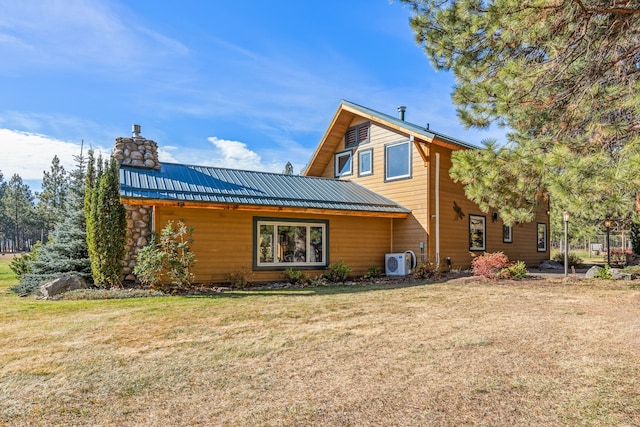 rear view of property with a lawn and ac unit